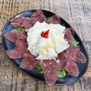 Carpaccio di carne salada con rucola e raspadura lodigiana (precio por ración)