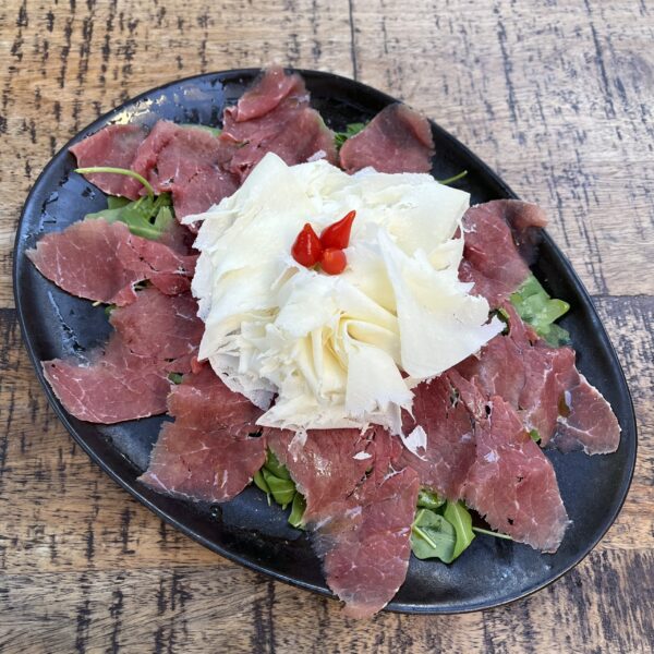 Carpaccio di carne salada con rucola e raspadura lodigiana (precio por ración)